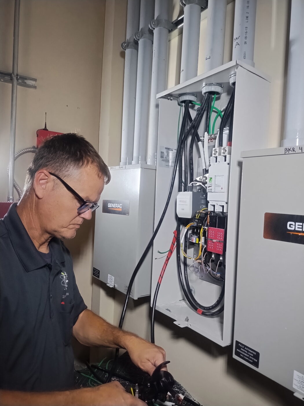 Dan House Electric electrician wiring a commercial Generac automatic transfer switch