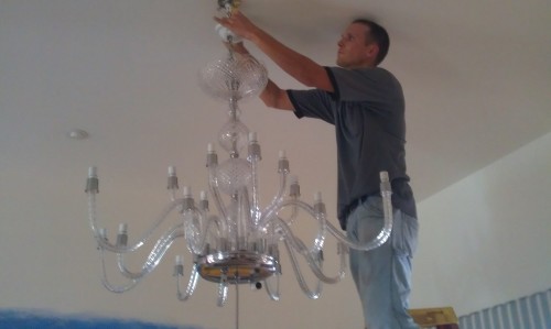 Dan House Electric installing a luxury crystal chandelier in a Naples home