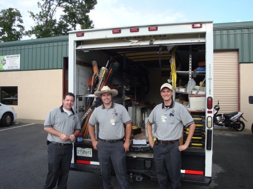Three Dan House Electric electricians by a fully stocked service truck