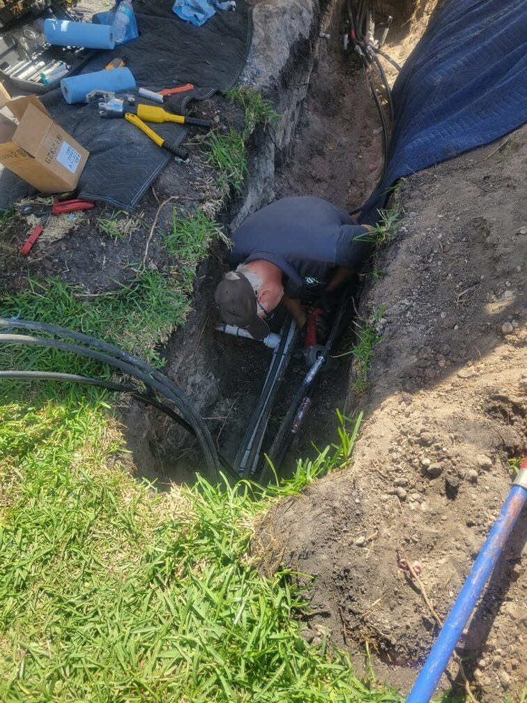 Dan House Electric electrician running underground conduit in a trench for a commercial service upgrade in Naples